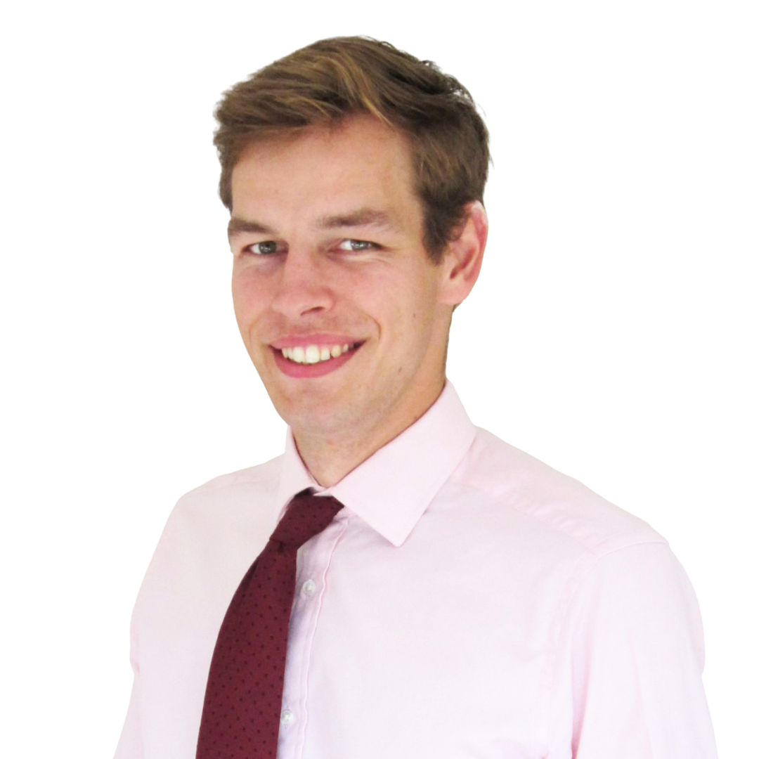 A man smiling while wearing a light pink dress shirt and a dark red tie, posed against a white background.