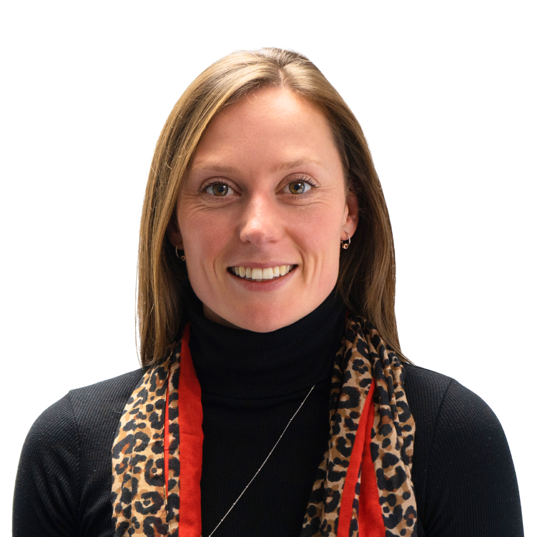 A woman with medium-length brown hair wearing a black turtleneck and a patterned scarf, smiling against a plain background.
